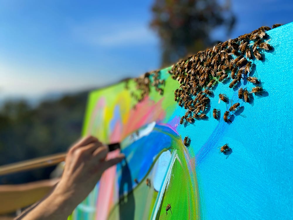 Bees gathered on a wet painted canvas as Steve Downs works
