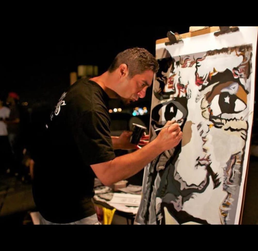 A younger Steve Downs painting a portrait at night, before the bee work