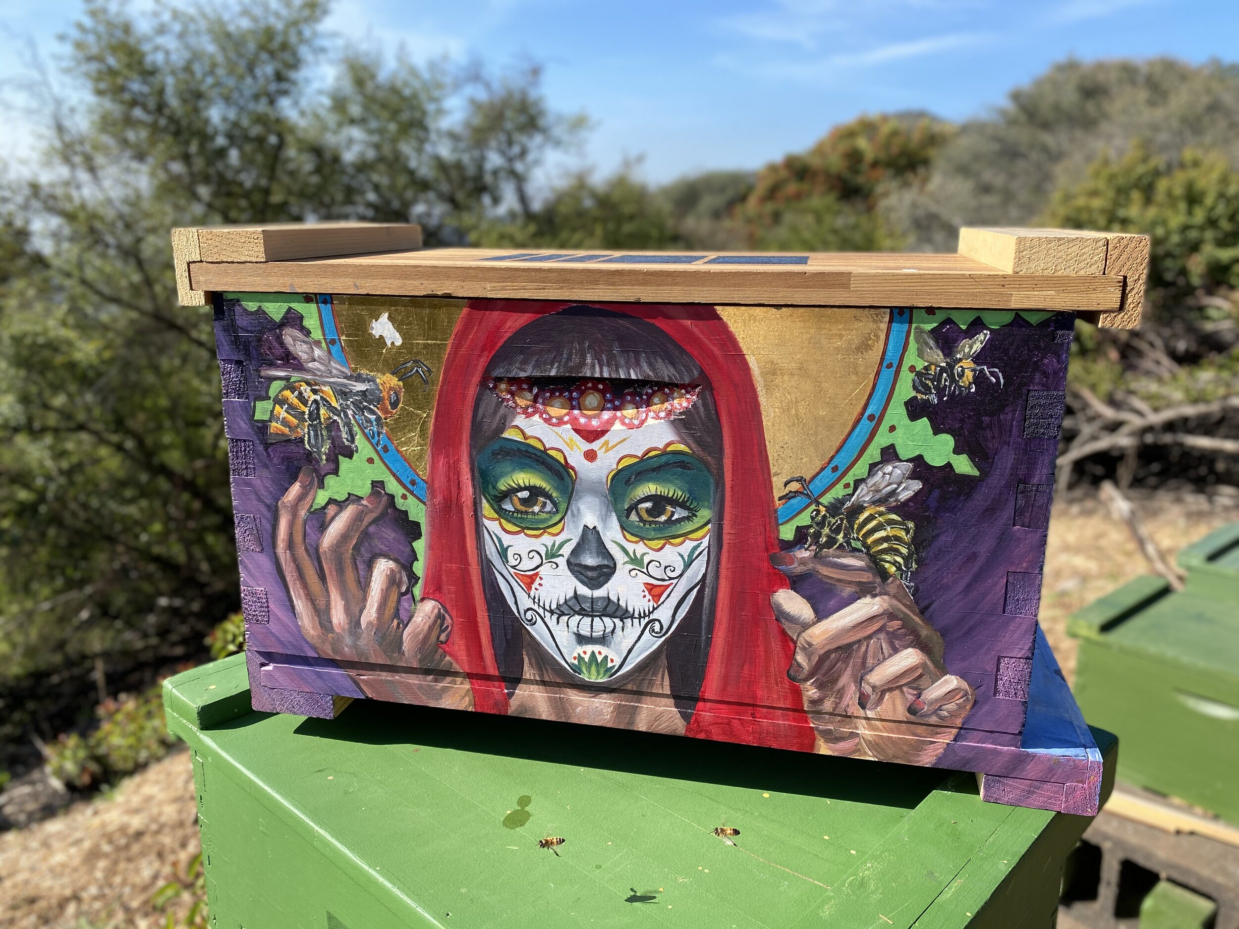 Beecasso bee box painted with full-face La Catrina sugar skull woman surrounded by honeybees