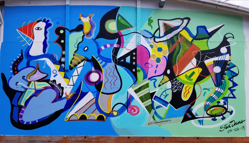 Large outdoor cubist mural by Steve Downs, abstract figures in blue, pink and green on building exterior, signed 05-02-19